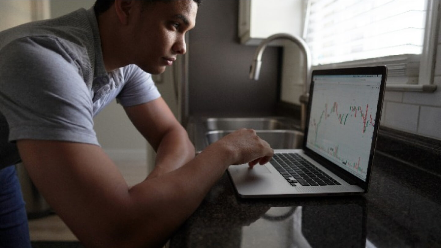 Người đang làm việc với biểu đồ Forex trên máy tính, tượng trưng cho việc xây dựng tâm lý vững vàng khi giao dịch Forex.